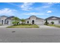 Street view of three elegant homes with well-kept lawns, stone driveways, and meticulously manicured greenery at 604 Mosaic Blvd, Daytona Beach, FL 32124