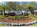 Elegant brick community sign amidst lush landscaping and mature palm trees at Sanctuary on Spruce Creek at 6123 Jasmine Vine Dr, Port Orange, FL 32128