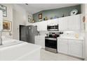 Bright kitchen featuring white cabinets, stainless steel appliances, and tiled floors at 6123 Jasmine Vine Dr, Port Orange, FL 32128
