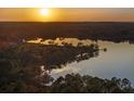 Sunset view overlooking the lake and horizon, with silhouettes of trees reflecting in the calm water at 22527 Lake Seneca Rd, Eustis, FL 32736