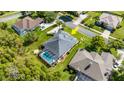Aerial view of a home featuring a screened pool, surrounded by lush greenery and neighboring houses at 3428 Rexford Cir, Ormond Beach, FL 32174