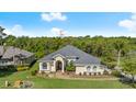 An elevated perspective of a beautiful single-story home with a well-kept yard and mature trees at 3428 Rexford Cir, Ormond Beach, FL 32174