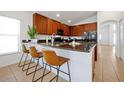 Modern kitchen with breakfast bar seating, granite countertops, dark wood cabinets and stainless appliances at 410 Viola Dr, Davenport, FL 33837