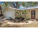 A well-maintained, single-story yellow home with a garage and mature landscaping at 1432 Mollie Rd, Daytona Beach, FL 32114