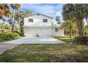 Charming two-story home with two-car garage, surrounded by lush tropical landscaping and sunny skies at 322 Garden St, Daytona Beach, FL 32114