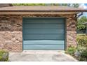Attached one car garage with a teal door and brick siding at 3385 Ne 44Th Pl, Ocala, FL 34479