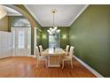 Formal dining area with stylish chandelier, complemented by green walls and bright lighting at 39601 Harbor Hills Blvd, Lady Lake, FL 32159