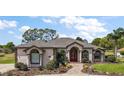 Charming single story home with beautiful landscaping, brick path, and decorative red front door at 39601 Harbor Hills Blvd, Lady Lake, FL 32159