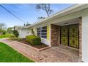 Inviting front porch with brick walkway and security gate at 59 Amsden Rd, Ormond Beach, FL 32176