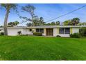 Well-kept single-story home featuring bright yellow shutters and lush green lawn at 59 Amsden Rd, Ormond Beach, FL 32176