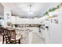 Bright kitchen featuring white cabinets, stone countertop island with seating, and modern appliances at 6172 Knotty Pine Ct, Port Orange, FL 32127