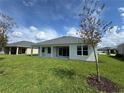 Well-maintained backyard featuring a covered patio and lush green lawn at 1010 Megano Blvd, Deland, FL 32724