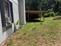 Side of home with a covered wooden structure and a view of the large grassy backyard at 230 Katrina St # 230, De Leon Springs, FL 32130