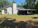 Exterior view of the home highlighting a covered structure and expansive backyard space at 230 Katrina St # 230, De Leon Springs, FL 32130