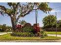 Community entrance sign featuring beautiful landscaping and mature trees at 1 Tomoka Oaks Blvd # 102, Ormond Beach, FL 32174