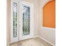 Elegant foyer with decorative glass front door and sidelight at 1128 Hansberry Ct, Ormond Beach, FL 32174
