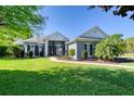 Beautifully landscaped front yard with mature tree and manicured lawn leading to this elegant home at 1404 Newry Cir, Ormond Beach, FL 32174