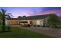 Charming home exterior features a brick driveway, manicured lawn and an attached garage with a classic car parked at 2924 River Point Dr, Daytona Beach, FL 32118