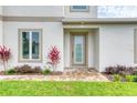 Close up of the modern front entrance with a glass door and landscaping at 32 Ocean Breeze Cir, Ormond Beach, FL 32176
