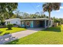 Well-kept single-story home featuring a carport, landscaped front yard, and welcoming curb appeal at 48 Rosewood Ave, Ormond Beach, FL 32174