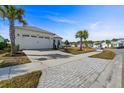 Well-maintained single Gathering home with palm trees, brick driveway, white exterior, and manicured landscaping at 540 Good Life Way, Daytona Beach, FL 32124