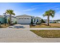 Well-maintained single Gathering home with palm trees, brick driveway, white exterior, and manicured landscaping at 540 Good Life Way, Daytona Beach, FL 32124