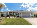 Well-manicured single-story home featuring a lush green lawn and attached two-car garage at 6809 Plumpjack Ct, Port Orange, FL 32128