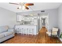Open living area with wood floors, and kitchen with a white bar and seating at 1441 N Atlantic Ave # 211, Daytona Beach, FL 32118