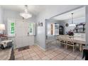 Welcoming entryway with tiled floor leading to the dining area with a chandelier and shuttered windows at 27 Winding Creek Way, Ormond Beach, FL 32174