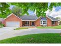 Charming single-story brick home with a two car garage, manicured lawn and inviting covered porch at 27 Winding Creek Way, Ormond Beach, FL 32174