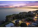 Stunning aerial view of the lakefront home at dusk, showcasing the home's proximity to the water and neighborhood at 3130 Indian Trl, Eustis, FL 32726