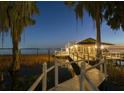 Beautifully illuminated dock and boathouse with seating, perfect for enjoying sunsets and water activities at 3130 Indian Trl, Eustis, FL 32726