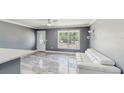 Bright living room featuring durable, marble-look flooring, a ceiling fan, and natural light at 330 Ponce Deleon Blvd, De Leon Springs, FL 32130