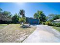 Detached garage with blue siding and mature trees at 330 Wall Ave, Ormond Beach, FL 32174