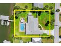 Aerial view of a home with a pool, manicured lawn, and a private boat lift on the water at 5809 Riverside Dr, Port Orange, FL 32127