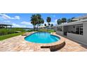 Backyard pool with surrounding brick pavers and lush landscaping, offering a private outdoor retreat at 5809 Riverside Dr, Port Orange, FL 32127