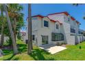 Exterior view of the home from the lush green backyard and patio area, featuring a sunroom at 200 Florida Shores Blvd, Daytona Beach, FL 32118