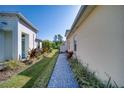 Side yard walkway with lush landscaping and brick pavers, enhancing the home's curb appeal at 324 Coral Reef Way, Daytona Beach, FL 32124