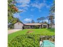 Charming single-story home featuring a well-kept lawn, attractive landscaping, and a delightful screened-in pool area at 75 Knollwood Estates Dr, Ormond Beach, FL 32174