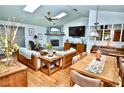 Inviting living room with vaulted ceilings, skylights, fireplace, and rustic wood furnishings at 75 Knollwood Estates Dr, Ormond Beach, FL 32174