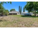 View of backyard and back of home, featuring an enclosed porch and well maintained lawn at 394 Golf Blvd, Daytona Beach, FL 32118