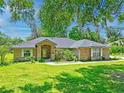Beautiful one story home with mature trees and a green lawn in a serene setting at 4008 Acoma Dr, Ormond Beach, FL 32174