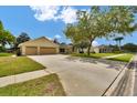 Charming one-story home with a wide driveway, attached two-car garage, and lush green lawn in a sunny setting at 518 Moon Rise Dr, Port Orange, FL 32127