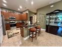Charming kitchen featuring granite counters, wood cabinets and bar seating, ideal for casual dining at 745 Aldenham Ln, Ormond Beach, FL 32174