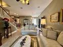 Cozy living room with couches, staircase, and a view of the dining area at 745 Aldenham Ln, Ormond Beach, FL 32174
