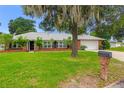 Attractive brick home featuring an attached garage and well-maintained landscaping, set on a green, expansive lawn at 11 Larisa Ter, Ormond Beach, FL 32174