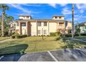 View of well-maintained townhouse exterior with a green lawn, trees, and blue sky at 133 Blue Heron Dr # C, Daytona Beach, FL 32119