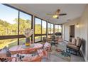 Bright sunroom with floor-to-ceiling windows, a ceiling fan, and a cozy seating area at 133 Blue Heron Dr # C, Daytona Beach, FL 32119