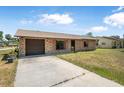 Charming brick home featuring an attached garage and a concrete driveway at 2 Wildwood Dr, Edgewater, FL 32132