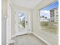 Bright entryway featuring tile flooring, a large window, and a white front door with glass panels at 3074 Ocean Shore Blvd, Ormond Beach, FL 32176
